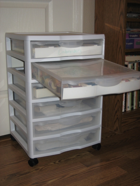 Rolling storage cart with removable lidded drawers.